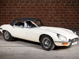 a white and black car parked in front of a brick wall