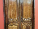 une paire de portes anciennes en bois dans une pièce aux murs rouges