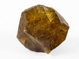 a close up of a piece of yellow quartz on a white surface