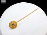 une broche en or ornée d'une pierre bleue au centre