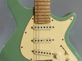 a close up of a green electric guitar with a white body
