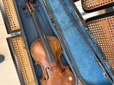 un violon dans son étui, posé sur une chaise