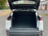 the back end of a white car with its trunk open