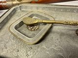 a silver tray with a spoon and a spoon rest on it