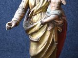 statue de Jésus tenant un enfant dans ses bras sur fond bleu
