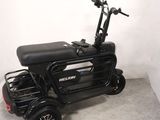 a small black scooter with a basket on the back of it