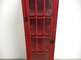 a red telephone booth with a glass door on the floor