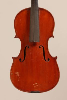 an old violin sitting on top of a white surface