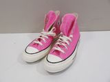 pink converses with white laces are sitting on a white surface