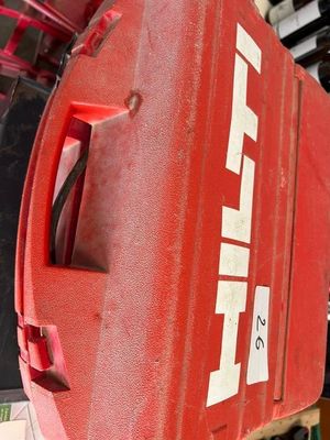 une valise rouge posée au sommet d'une pile de bagages