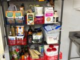 une étagère métallique sur laquelle sont posés de nombreux objets, dans une cuisine