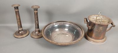 a silver bowl and two candles on a table