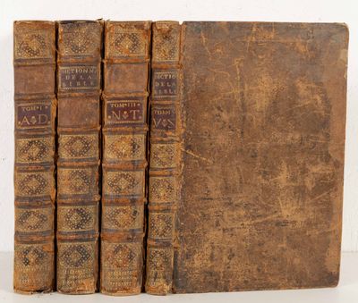 trois vieux livres sont empilés sur une table