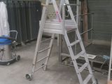 une échelle posée dans une pièce, à côté d'une chaise