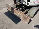 a tractor with a plow attachment attached to it ' s back