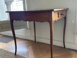 a small table with a drawer on it in a room