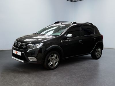Le SUV noir est garé dans une grande pièce où se trouve une horloge accrochée au mur.