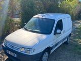 une camionnette blanche garée sur le bord d'un chemin de terre