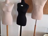 three mannequins in a room with a cork board on the wall