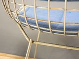 a metal chair with a blue cushion on top of it