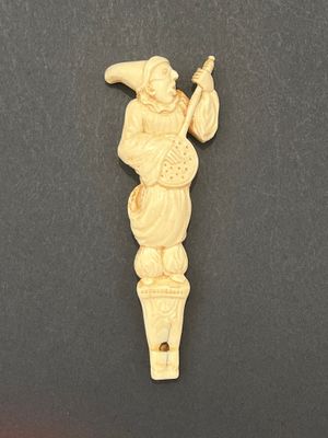 une figurine en ivoire sculpté représentant un homme tenant une pipe