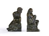 une paire de sculptures en bronze représentant un homme et une femme assis sur un rocher