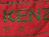 the label of a red jacket with green writing on it