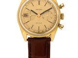 a close up of a watch on a white background with a brown strap