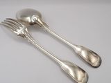 two silver spoons and a fork on a white surface