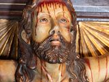 a statue of jesus on a cross with blood on it