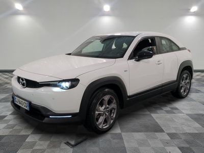 the white mazda cx - hr suv is parked on a checkered floor