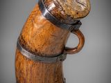 a close up of a wooden vase with a handle on a gray background