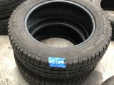 Plusieurs pneus sont alignés par terre, chacun muni d'un autocollant bleu.
