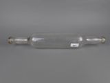 une bouteille en verre vide munie d'un bouchon métallique, posée sur une surface grise