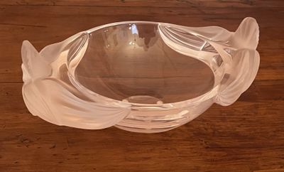 a glass bowl on a wooden table with a light in the background