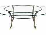 une table ronde en verre avec des pieds en métal et un plateau en verre
