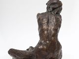 a bronze statue of a woman sitting on a black base