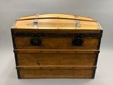 une vieille malle en bois avec des sangles métalliques et un couvercle en bois