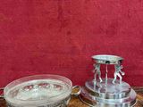 deux bougeoirs en argent et un bol posés sur une table en bois