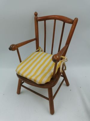 une image représentant une chaise en bois avec un coussin d'assise rayé jaune et blanc