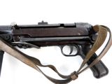an old machine gun with a leather strap on a white background
