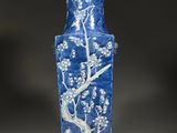 a blue and white vase with a tree design on it