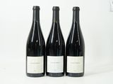 trois bouteilles de vin posées l'une à côté de l'autre sur une table