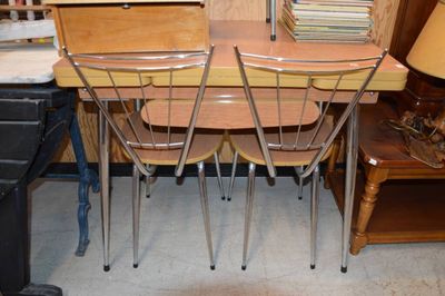 une table avec quatre chaises et une lampe posée dessus
