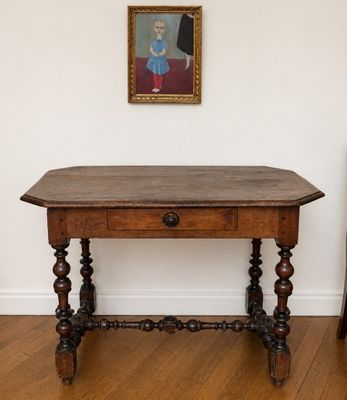 une petite table avec un plateau en bois et un tableau accroché au mur