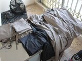 an image of a messy room with a laptop and a pile of clothes
