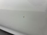 a close up of a spider crawling on the hood of a white car