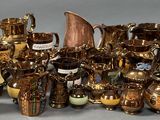 many different types of gold and silver vases on the table