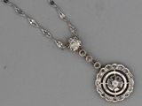 une photo d'un collier en argent orné d'un motif floral