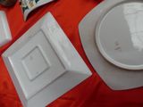 a white plate and a white bowl on a red table cloth